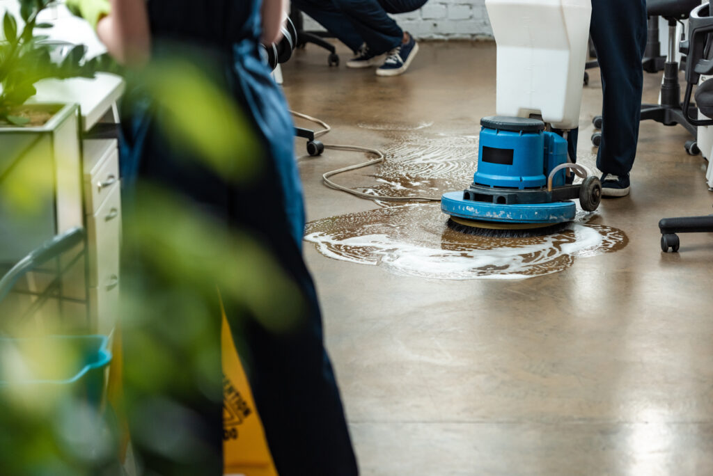 cropped view of cleaner washing floor with cleaning machine near